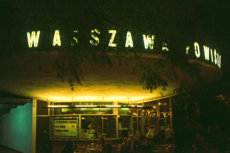 a crowd of people gather around a building on a dark night