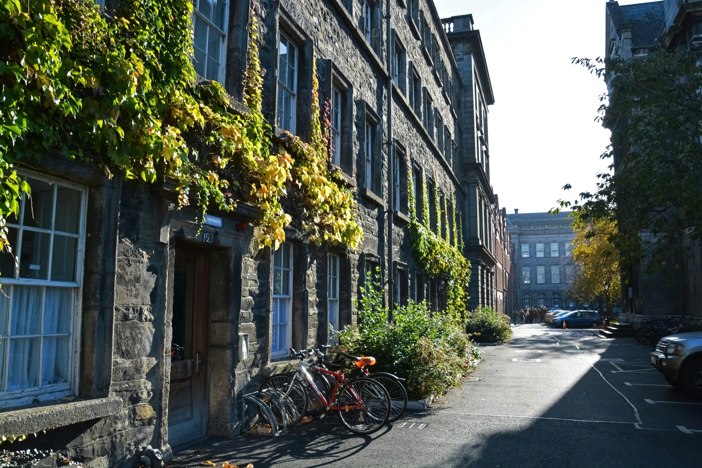 many bicycles sit outside of a stone building