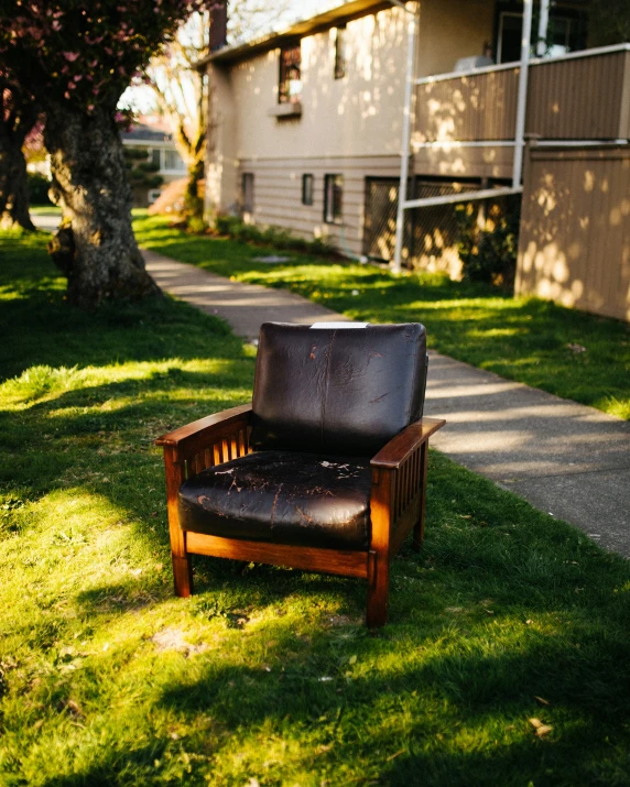 a chair and pillow on grass in front of buildings