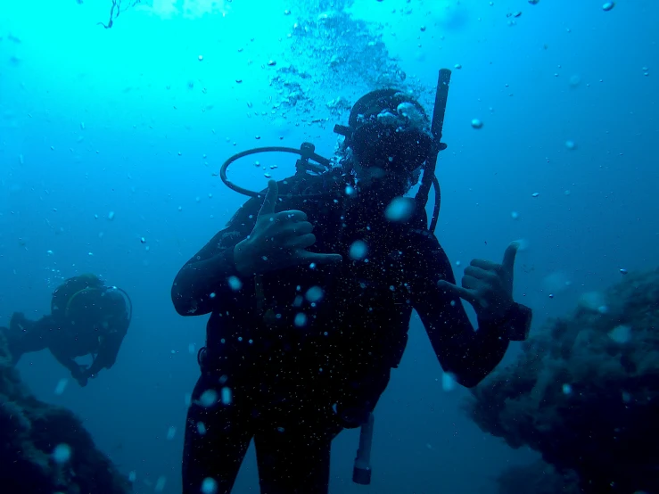 the man in scuba suit is holding onto the pole