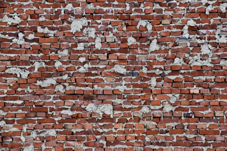 a brick wall with white and brown patches of paint