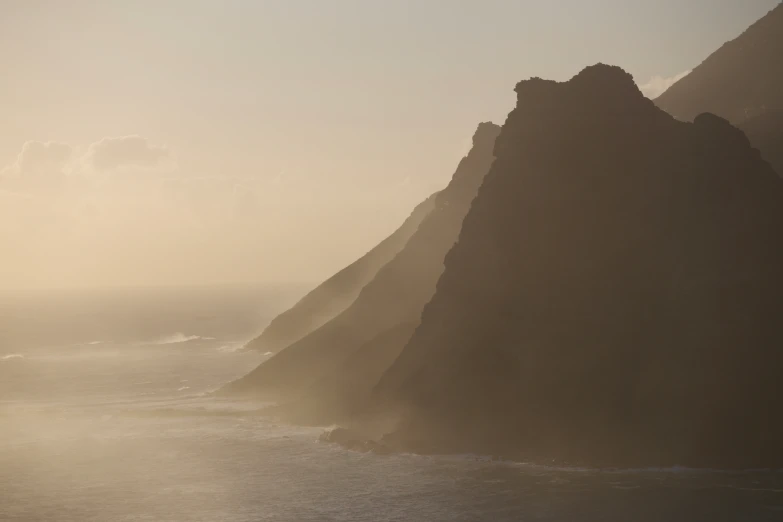 the ocean waves are crashing against the rocky, steep coastline