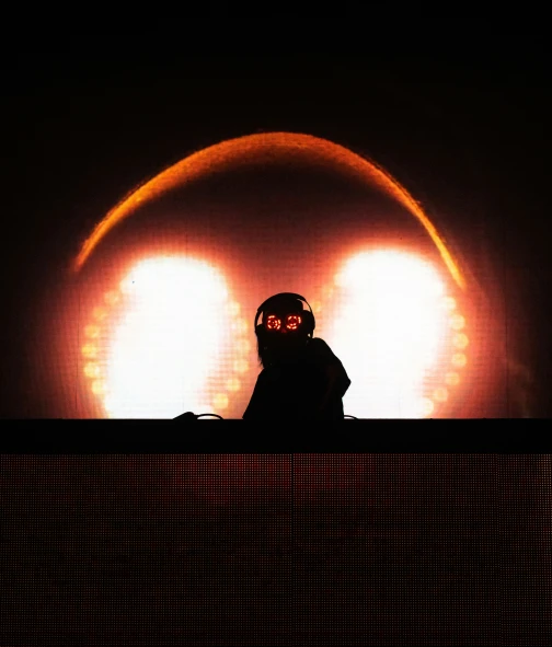 a person on stage holding a glowing mask
