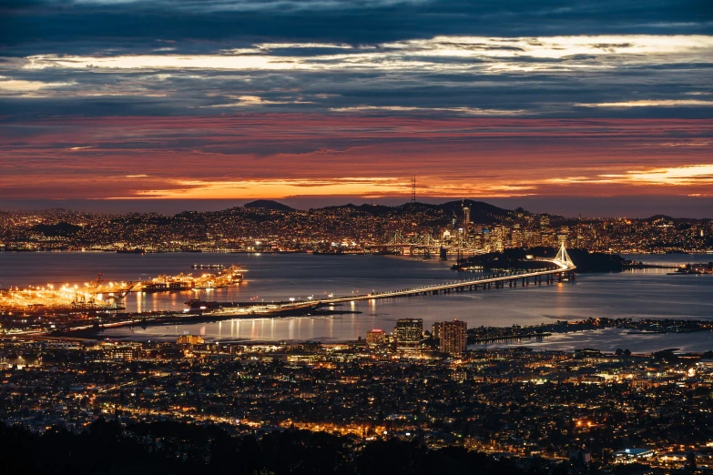 some lights on in the water and buildings on a hill