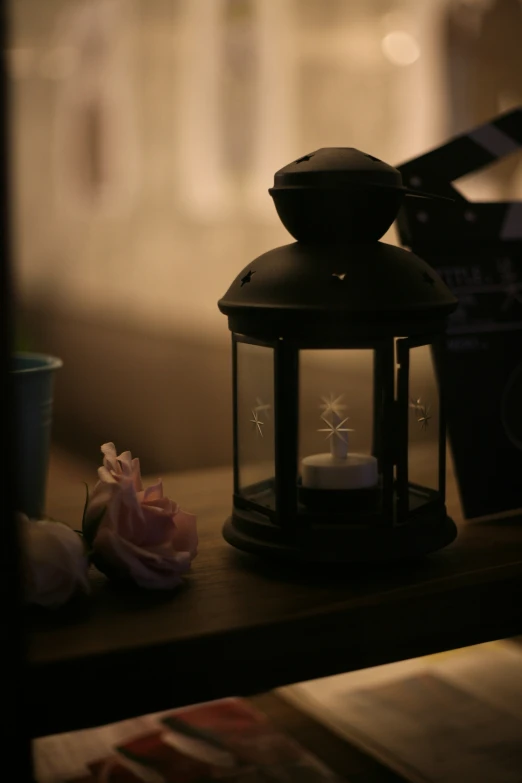 a close - up of a lit candle, a cup, and two books