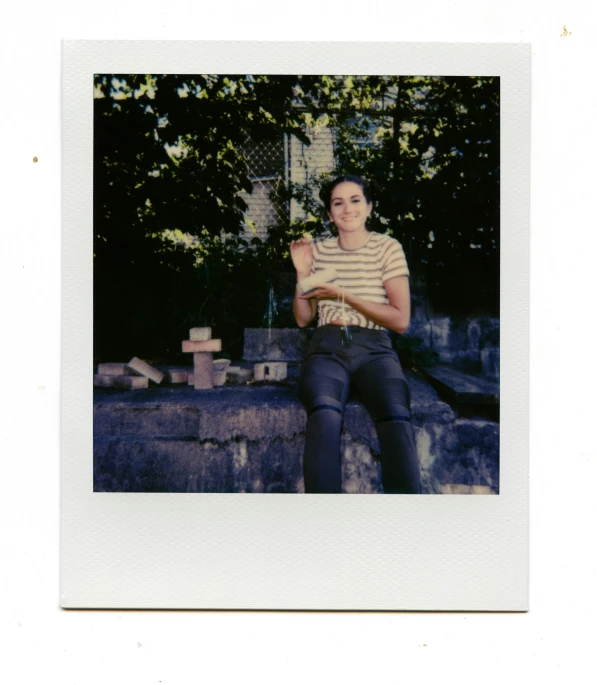 a young man wearing a striped shirt sitting outside