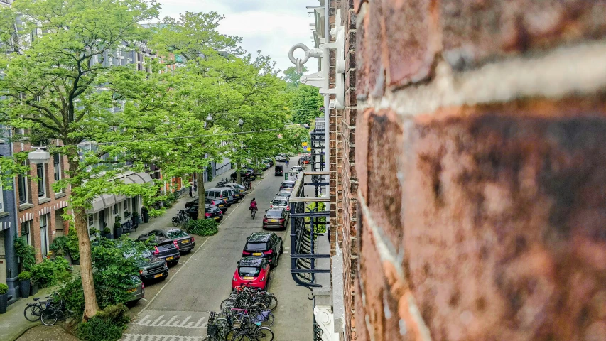 a small narrow street with parked cars and bicycles