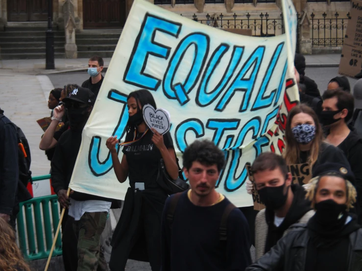 a group of people with masks holding signs