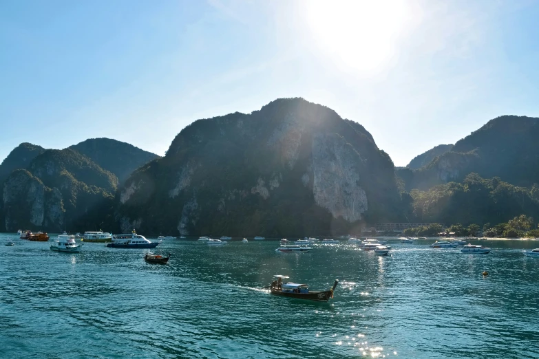 several boats in a bay with mountains in the background