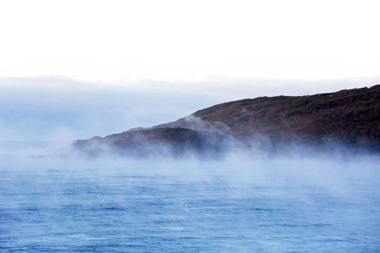 an image of water with mist rising from the lake