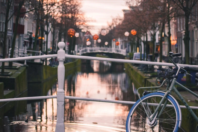 blue bike parked on the corner of a canal