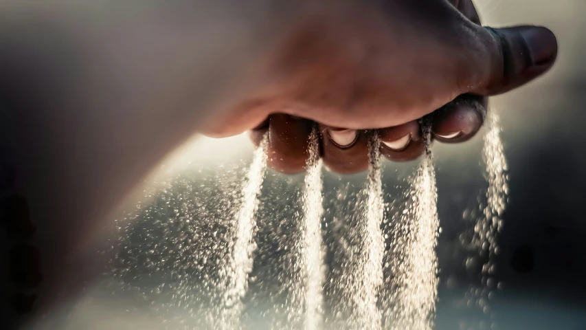 hand holding out soing in the air with water droplets pouring from it