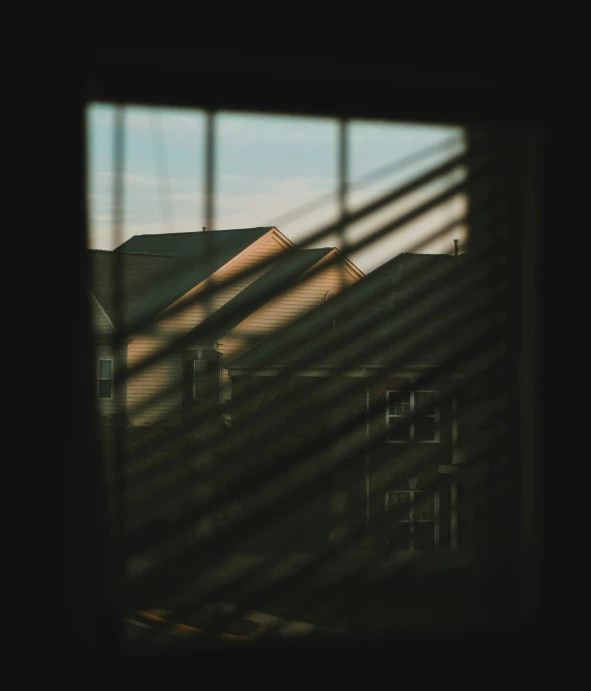 view of houses through the blinds of an air conditioner