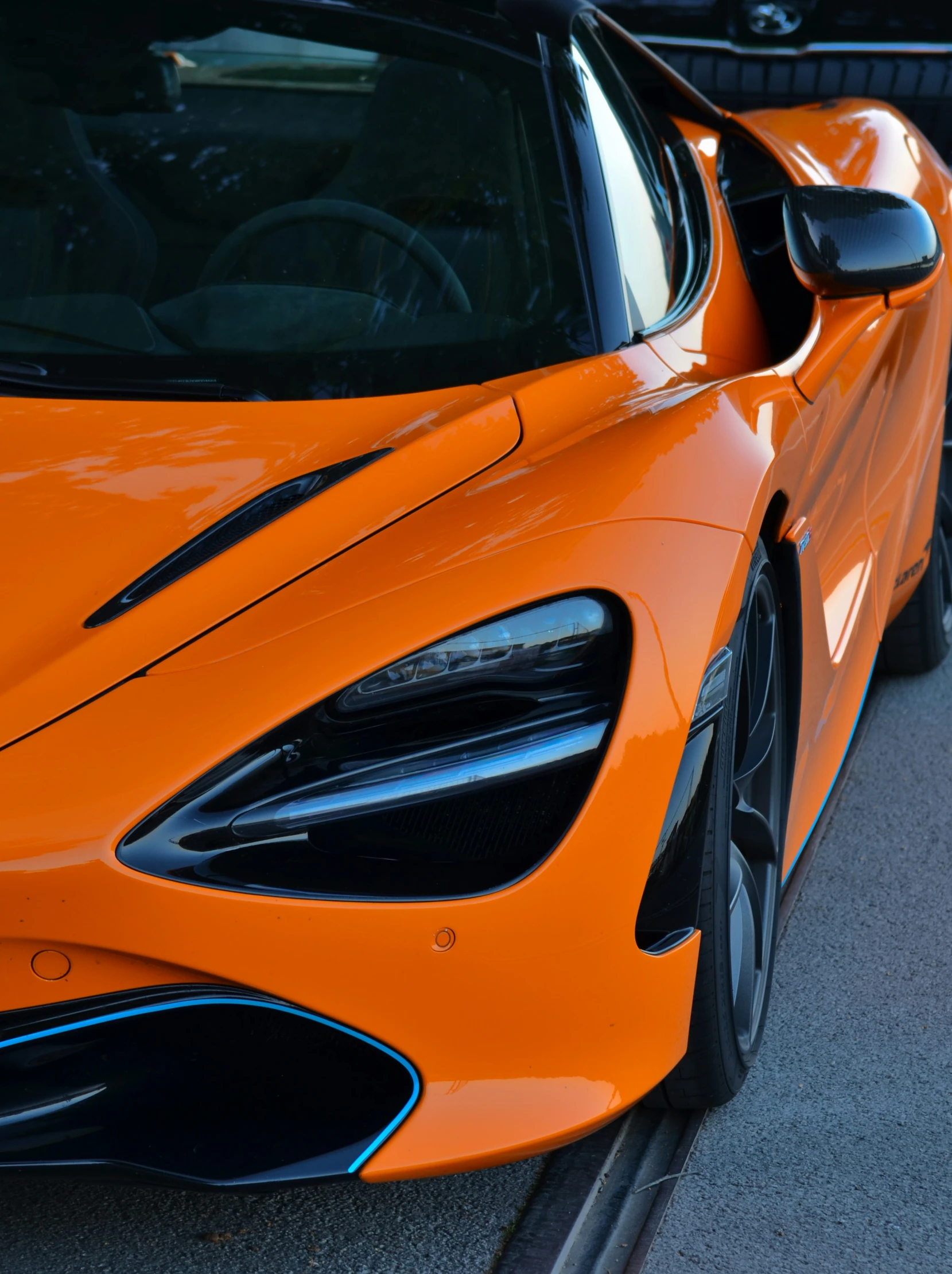 a car with orange paint sitting next to another car