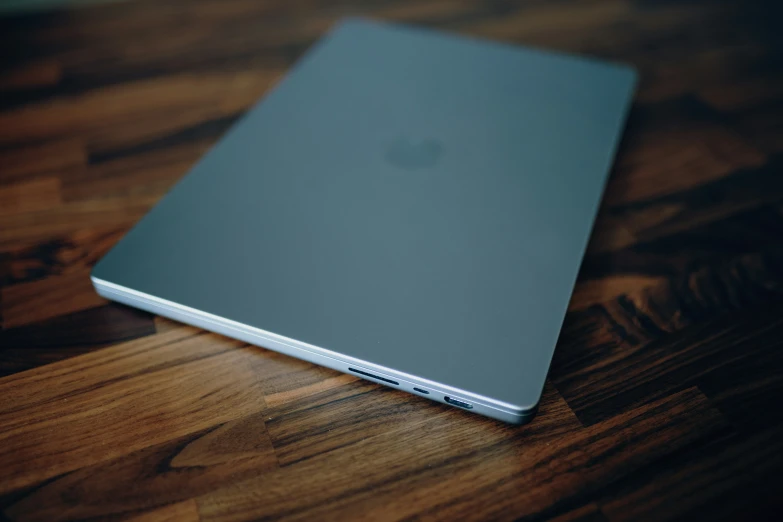 a silver apple laptop is laying on the table