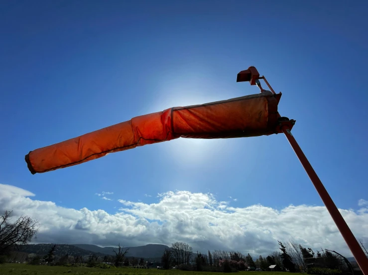 a close up of a red metal pole on the side of the road