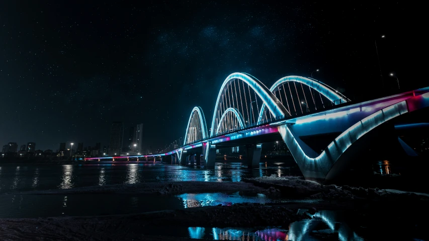 a brightly lit bridge over a body of water