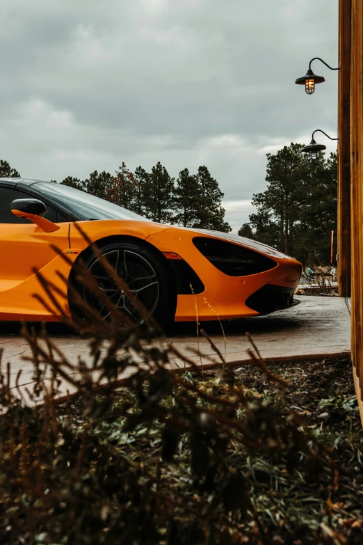 an orange sports car parked on top of a parking lot