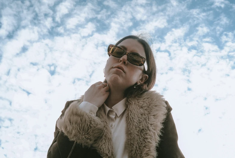 a woman wearing sunglasses and a fur vest