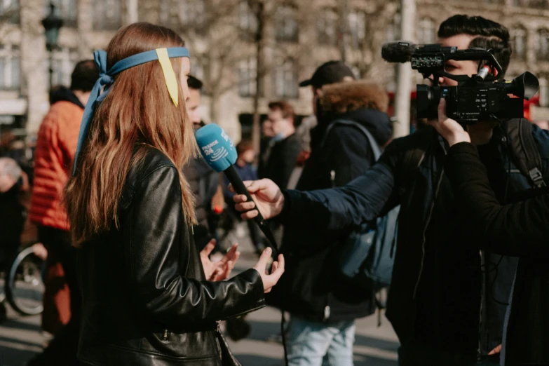 woman speaking to man while microphone is recording in the street