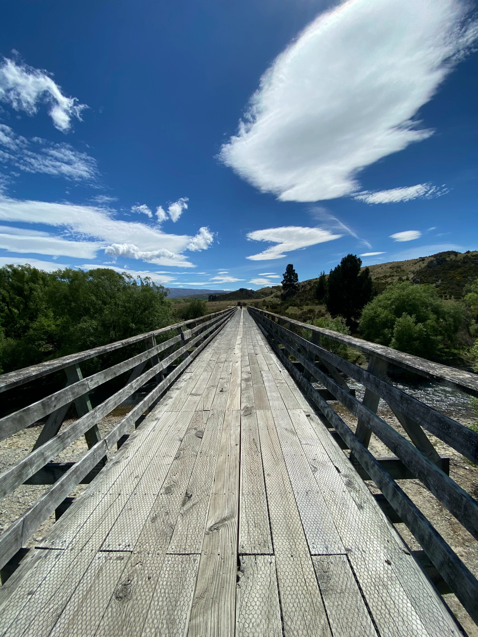 the wooden bridge has railings that lead to different sides