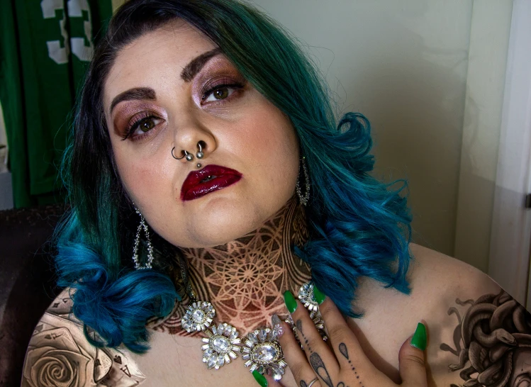 a woman wearing a green choke necklace with piercings and a turquoise hair