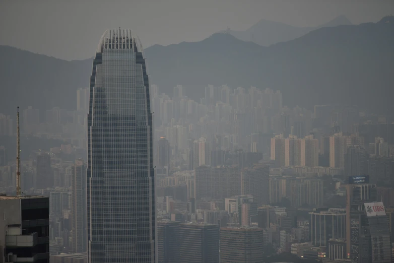 the large skyscr is surrounded by mountains and fog