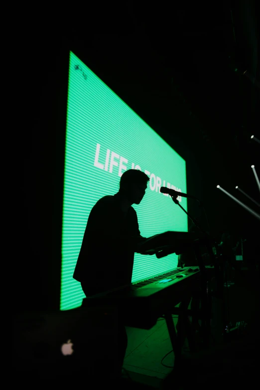 a man standing next to a microphone and an apple sign