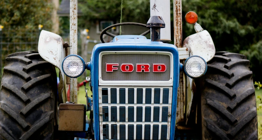 front view of a blue farm tractor with the ford logo on it
