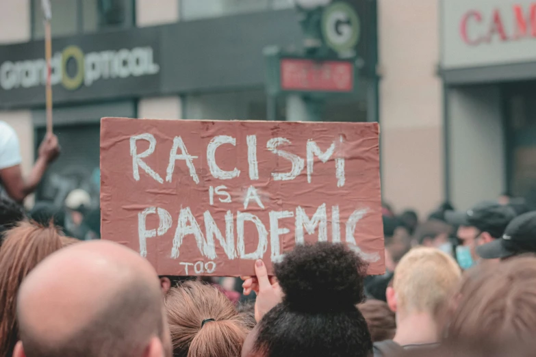 people are holding up a protest sign outside a building