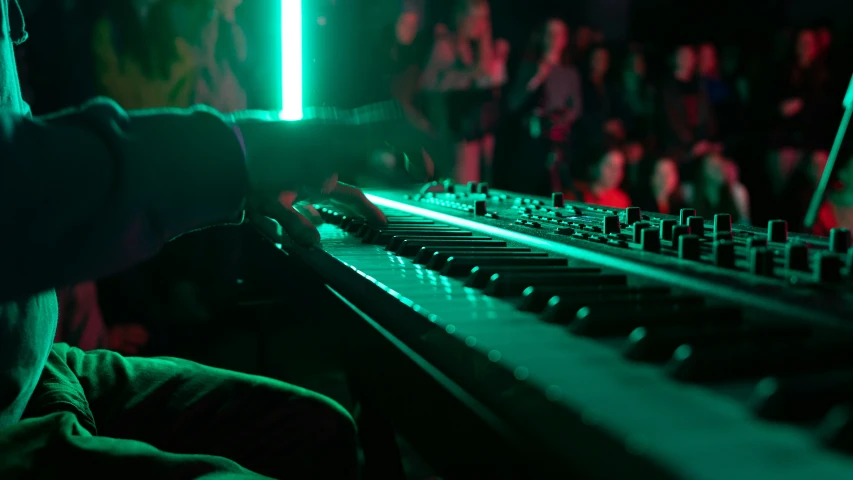 a person playing on an electric keyboard in a dark room