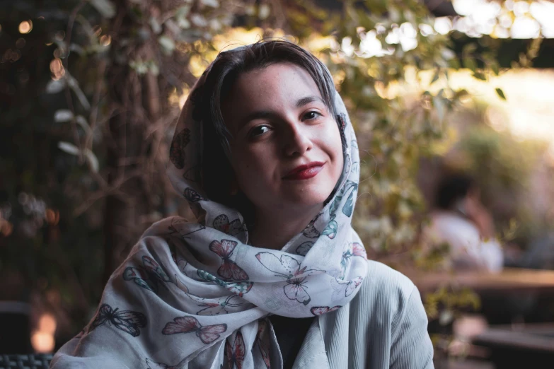 an attractive woman wearing a scarf on top of her head