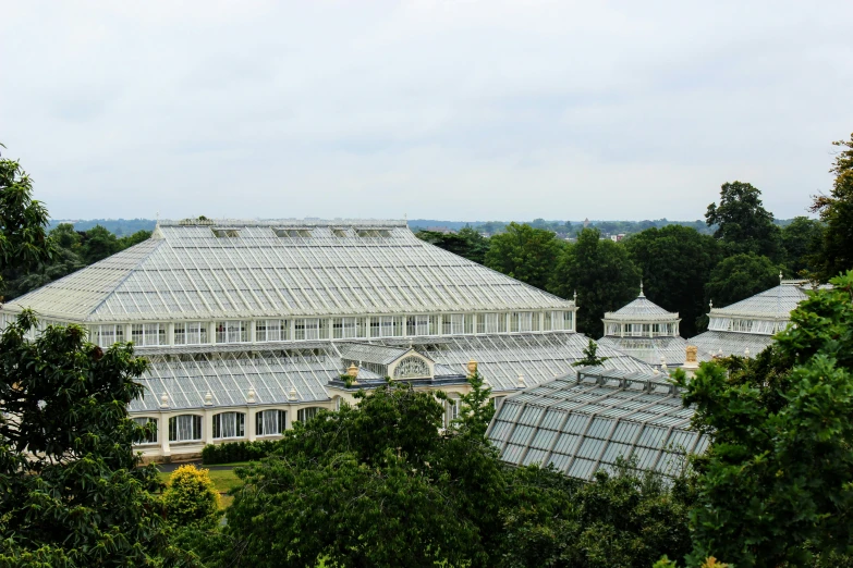 a large glass building in front of trees