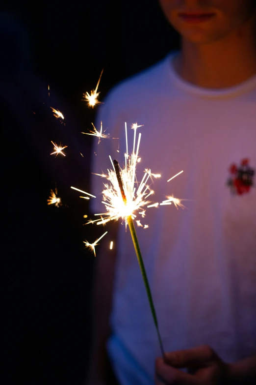 the sparkler on top of a womans white t - shirt is glowing brightly