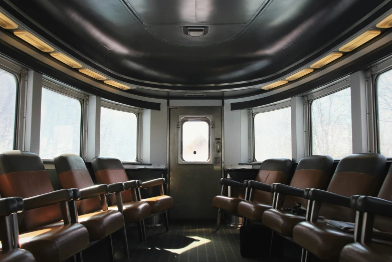 empty chairs are arranged in front of three windows on a bus