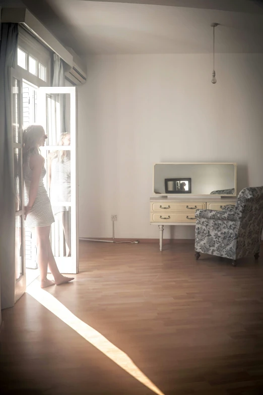 a little girl is standing in the room looking through a door