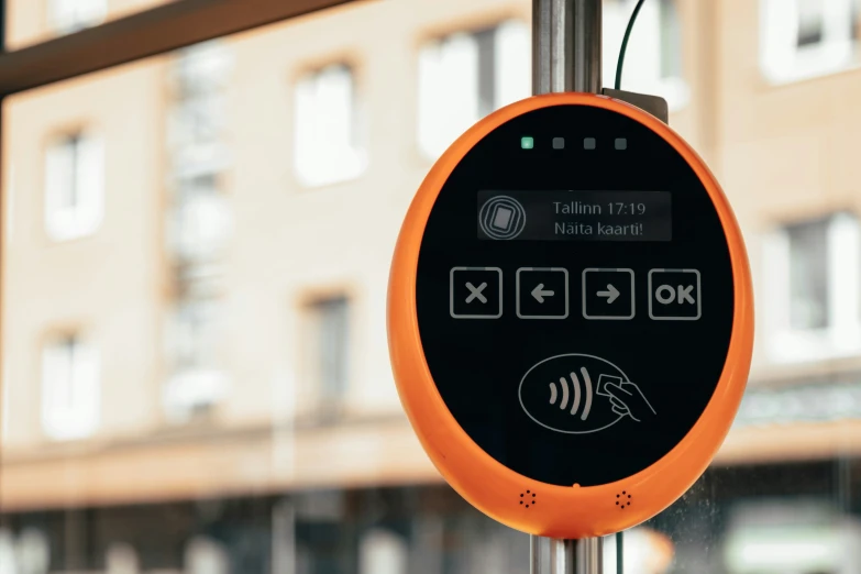 a small orange device mounted on a metal pole