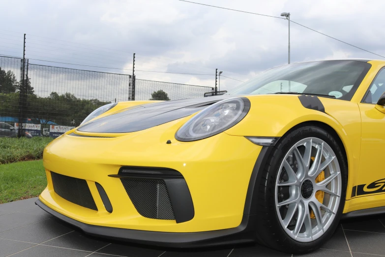 a yellow sports car with an emblem on it's side