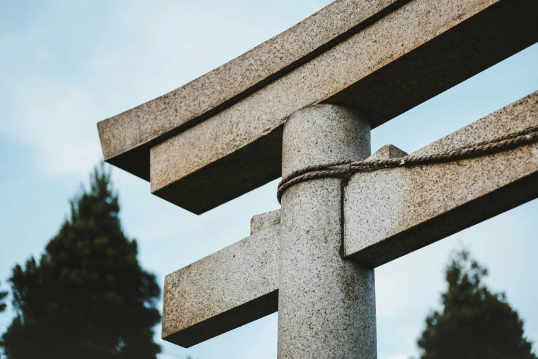 a large cross - shaped object is tied up on top of a concrete structure