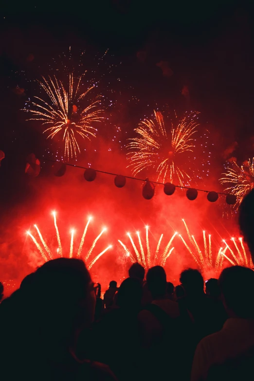 people watching a show with red fireworks