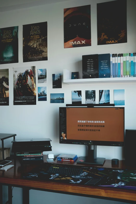 a desktop computer and monitor on a desk in a room with some pictures on the wall