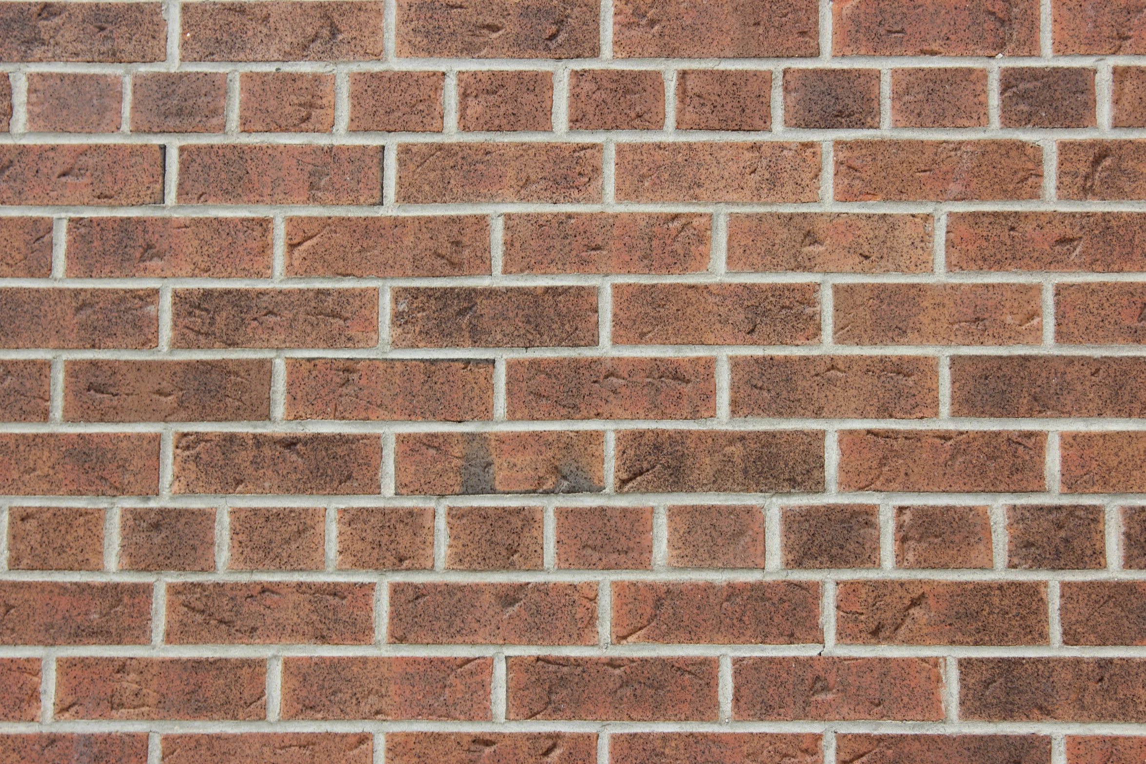 a brown brick wall with some black squares