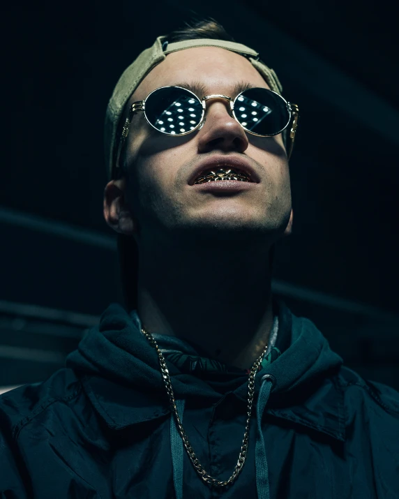 a man wearing sunglasses with a hood and a chain