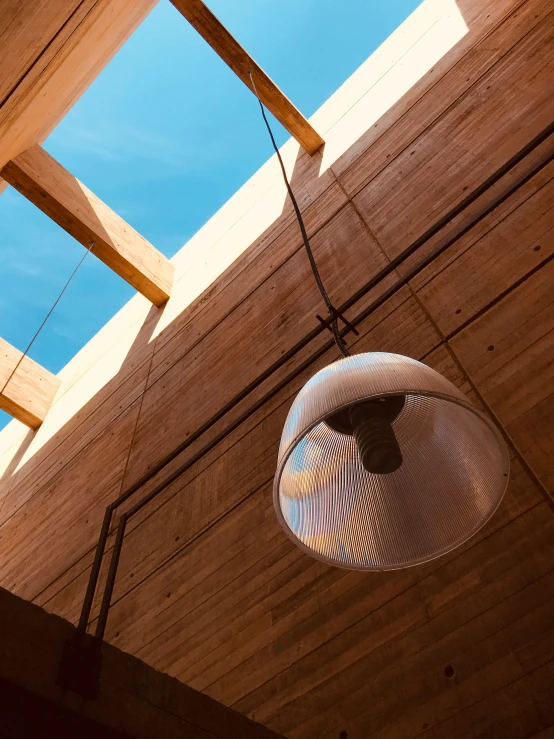an outdoor hanging light in the ceiling of a wooden building