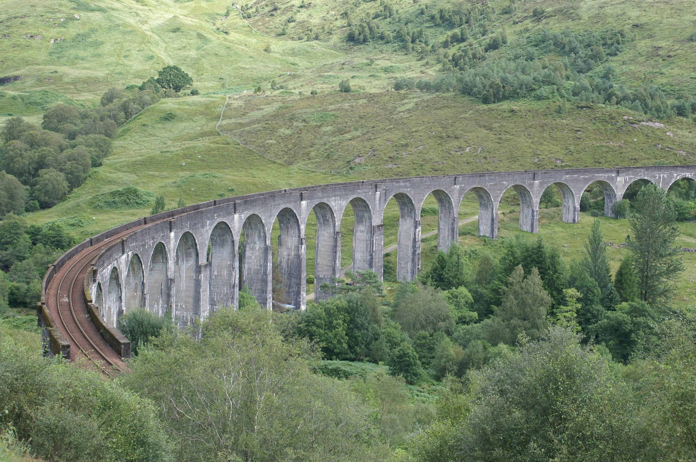 an old train crossing over a bridge in the mountains