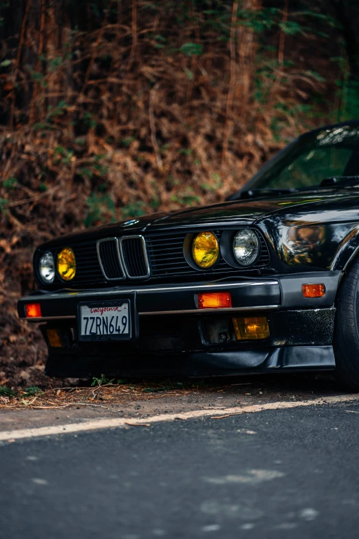 black bmw coupe parked on the side of a road