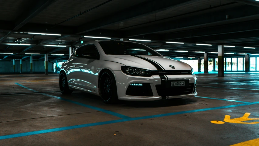 a white car with black stripes parked in the dark