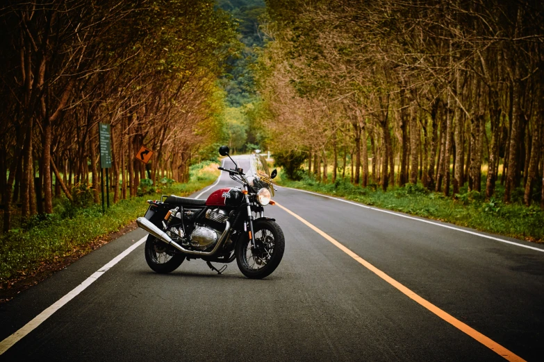 a motorcycle parked on the side of the road next to trees