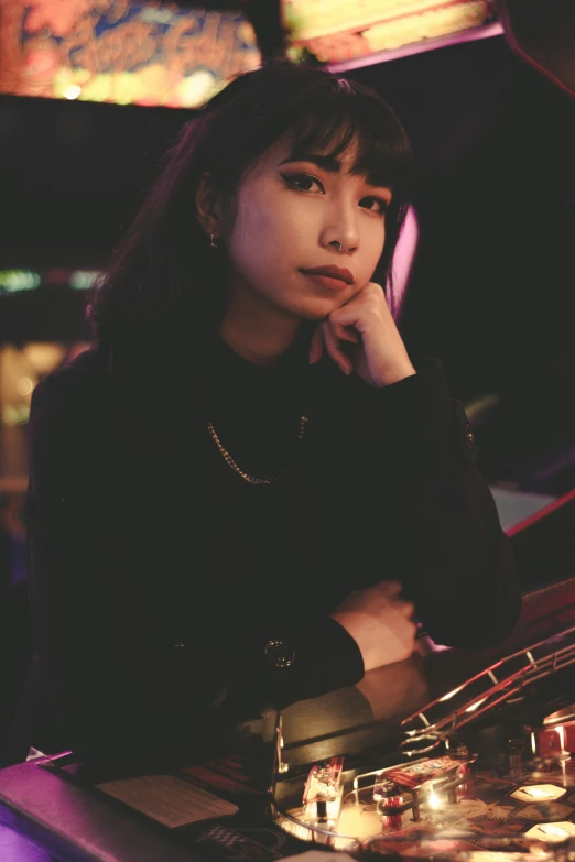 a young asian woman leaning her head against a glass with her hands on her chin