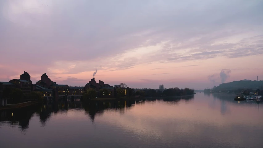 view of town across river in twilight with fog